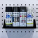 A Triton black steel shelf holding three spray cans.