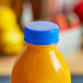 A Royal Blue tamper-evident cap on a bottle of orange juice.