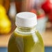 A White Unlined Tamper-Evident Cap on a bottle of green juice.