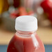 A Clear Tamper-Evident Cap on a bottle of pink liquid.