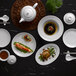 A table set with Luzerne white porcelain plates, bowls, and teapot.