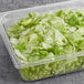 A plastic container with Romaine and Iceberg lettuce chopped salad mix in it.