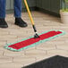 A person using a Lavex microfiber dust mop on a tile floor.