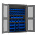 A metal Durham storage cabinet with blue bins inside.