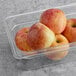 A plastic container with Fresh Fuji Apples in it.