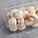 A plastic container of Silver Dollar white mushrooms.