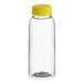 A clear plastic juice bottle with a yellow cap.