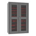 A grey metal Durham storage cabinet with red mesh doors and red bins.