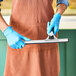 A person wearing blue gloves using an Ettore 1914 aluminum squeegee.