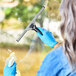A person wearing blue gloves uses an Ettore Pro+ squeegee to clean a window.
