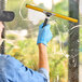 A hand using an Ettore squeegee to clean a window