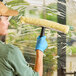 A woman using a yellow and white Ettore window washer to clean a window.