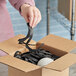 A person holding a black strip of SpiroPack black spiral tissue paper.