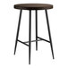 A Lancaster Table & Seating round butcher block bar table with black legs.