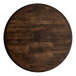 A Lancaster Table & Seating round wooden bar height table top with a dark wood finish.