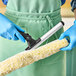 A person wearing blue gloves holding an Ettore Pro+ Super System window washer.