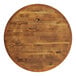A Lancaster Table & Seating round butcher block table top on a wooden base.