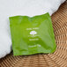 A green Basic Earth Botanicals package on a white towel.