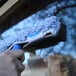 A 10-inch Ettore Mighty Washer microfiber strip window washer sleeve being used to clean a window.