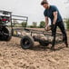 A man loading a Gorilla heavy-duty steel ATV trailer.