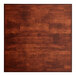 A wooden butcher block table top with a mahogany finish.