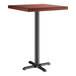 A Lancaster Table & Seating square bar height table with a mahogany wood top and black cast iron base plate.