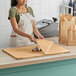 A woman in an apron cutting SatinWrap Harvest Gold tissue paper on a counter.