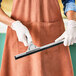 A person holding an Ettore 16" aluminum squeegee channel with rubber blade.