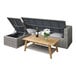 An outdoor wicker sectional with a table holding wine and glasses.