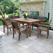 An Outdoor Interiors Eucalyptus stackable arm chair and table on a patio.