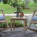 An Outdoor Interiors eucalyptus accent table with wine glasses and a bottle of wine on it.