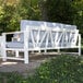 An Outdoor Interiors white aluminum sofa with blue cushions on an outdoor patio.