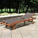 An Outdoor Interiors Eucalyptus chaise lounge on a stone patio.