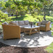 An Outdoor Interiors wicker arm chair and table on a stone patio.