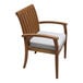 An Outdoor Interiors Eucalyptus stackable arm chair with a beige cushion.