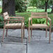 Two Outdoor Interiors antique wash eucalyptus wooden chairs on a stone patio.