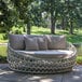 An Outdoor Interiors round linen rope daybed with gray cushions and pillows on a white background.