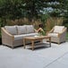 An Outdoor Interiors teak and ash wicker 3-seater sofa and table on a patio.