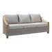 An Outdoor Interiors teak and ash wicker sofa with white cushions on it.