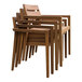 A stack of four Outdoor Interiors brown umber eucalyptus wooden dining chairs with arms.