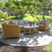 An Outdoor Interiors wicker sofa and table on a stone patio.