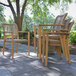 A group of Outdoor Interiors Nautical Rope and Antique Wash Eucalyptus stackable chairs on a patio.