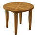 An Outdoor Interiors round teak table with a cross pattern on the top.