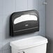 A black surface-mounted Lavex toilet seat cover dispenser over a toilet.