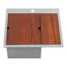 A rectangular stainless steel sink with a glass rinser on a wooden surface.