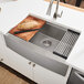 A Ruvati stainless steel farmhouse sink with a wooden cutting board over the basin.