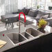 A close-up of a Ruvati stainless steel triple-bowl sink.