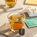 A glass cup of Stash Moroccan Mint Green Tea with a tea bag tag on top of it.