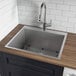 A Ruvati stainless steel sink with a faucet on a counter.