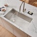 A Ruvati stainless steel undermount sink with a drain in it.